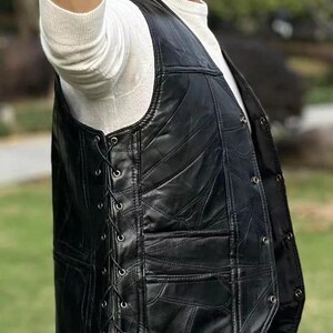 K&ouml;nnte beinhalten: Schwarze Lederweste mit Patchwork-Design. Die Weste hat einen Schn&uuml;rverschluss auf der linken Seite und Knopfverschl&uuml;sse auf der rechten Seite. Die Weste hat einen klassischen Biker-Stil mit tailliertem Schnitt.