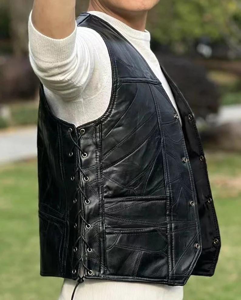 K&ouml;nnte beinhalten: Schwarze Lederweste mit Patchwork-Design. Die Weste hat einen Schn&uuml;rverschluss auf der linken Seite und Knopfverschl&uuml;sse auf der rechten Seite. Die Weste hat einen klassischen Biker-Stil mit tailliertem Schnitt.