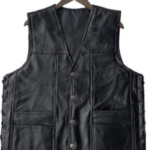 K&ouml;nnte beinhalten: Schwarze Lederweste mit V-Ausschnitt und vier dekorativen Kn&ouml;pfen. Die Weste hat zwei Vordertaschen und seitliche Schn&uuml;rungen. Das Leder ist in einem Patchwork-Design gen&auml;ht. Die Weste h&auml;ngt an einem Holzb&uuml;gel.