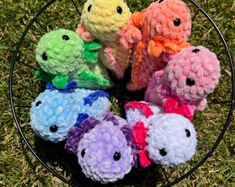 May include: A collection of seven crocheted axolotl plushies in a wire basket. The plushies are in various colours, including yellow, orange, pink, green, blue, purple, and white.
