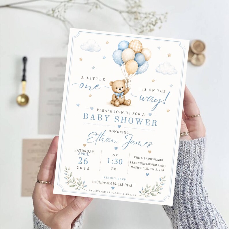 May include: A rectangular baby shower invitation card featuring a watercolor illustration of a teddy bear holding a cluster of blue, cream, and plaid balloons. The text reads A LITTLE one IS ON THE WAY! BABY SHOWER honoring Ethan James.
