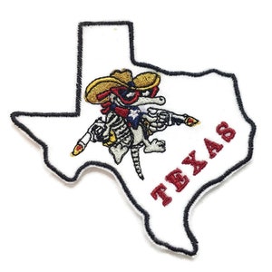 May include: Embroidered patch featuring a cartoon armadillo wearing a cowboy hat and sunglasses, holding two pistols, in front of an outline of the state of Texas with the word "TEXAS" in red lettering.