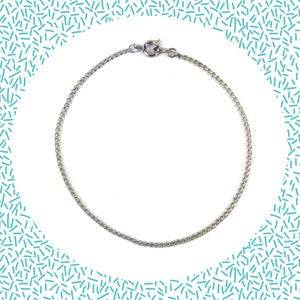 Puede incluir: Un brazalete de cadena de plata con cierre de langosta.