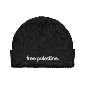 Könnte beinhalten: Schwarze Strickmütze mit dem in Weiß gestickten Text "free palestine."