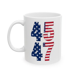 May include: White ceramic mug with the numbers 45 and 47 printed on it. The numbers are decorated with an American flag pattern.