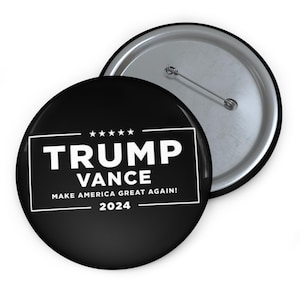 May include: Black and white button with the text "TRUMP VANCE MAKE AMERICA GREAT AGAIN! 2024" in a white rectangle with five stars above the text.