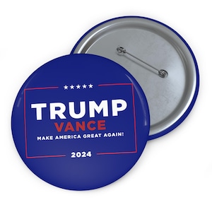 May include: A blue and red political campaign button with the text "TRUMP VANCE MAKE AMERICA GREAT AGAIN! 2024"