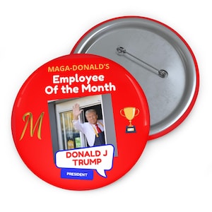 May include: Red button with a gold M and the text "Maga-Donald's Employee of the Month" with a picture of Donald J. Trump in a McDonald's uniform and a gold trophy. The text "Donald J. Trump President" is in a speech bubble.