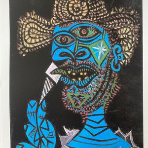 Könnte beinhalten: Ein farbenfroher Lithographiedruck eines Mannes mit einem großen Strohhut und einem blauen Hemd. Der Mann hält ein weißes Objekt in der Hand und hat ein großes, ausdrucksstarkes Gesicht. Der Druck ist unten rechts mit "Picasso" signiert und unten links mit "1/100" nummeriert.