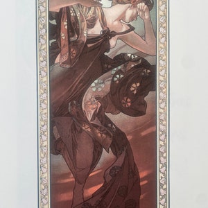 May include: A vintage art nouveau print depicting a woman in a flowing gown with a floral design. The woman is shown with her head resting on her hand, looking down. The print is framed with a decorative border.