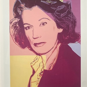 May include: A colorful portrait print of a woman with dark hair, wearing a dark shirt. The background is a mix of pink, yellow, and purple. The print is signed "Andy Warhol" in the bottom right corner and numbered "6/100" in the bottom left corner.