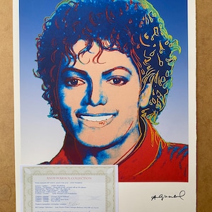 Op de afbeelding: Een kleurrijk pop-art lithografie portret van Michael Jackson door Andy Warhol, met levendige blauwe, rode en perzikkleurige tinten. De print bevat een handtekening in de rechterbenedenhoek en een bijgevoegd certificaat van echtheid.