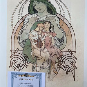 May include: A vintage art print depicting a woman in a green gown holding two other women. The print is framed by a decorative border of stars and swirls. The print is titled "Alfons Maria Mucha" and includes a certificate of authenticity.