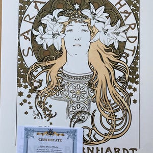 May include: A vintage poster featuring a woman with flowing blonde hair adorned with lilies. The poster is in shades of gold and brown with a decorative border and the text "SARAH BERNHARDT" in a circular frame. The text "et ses amis" is at the bottom of the poster.