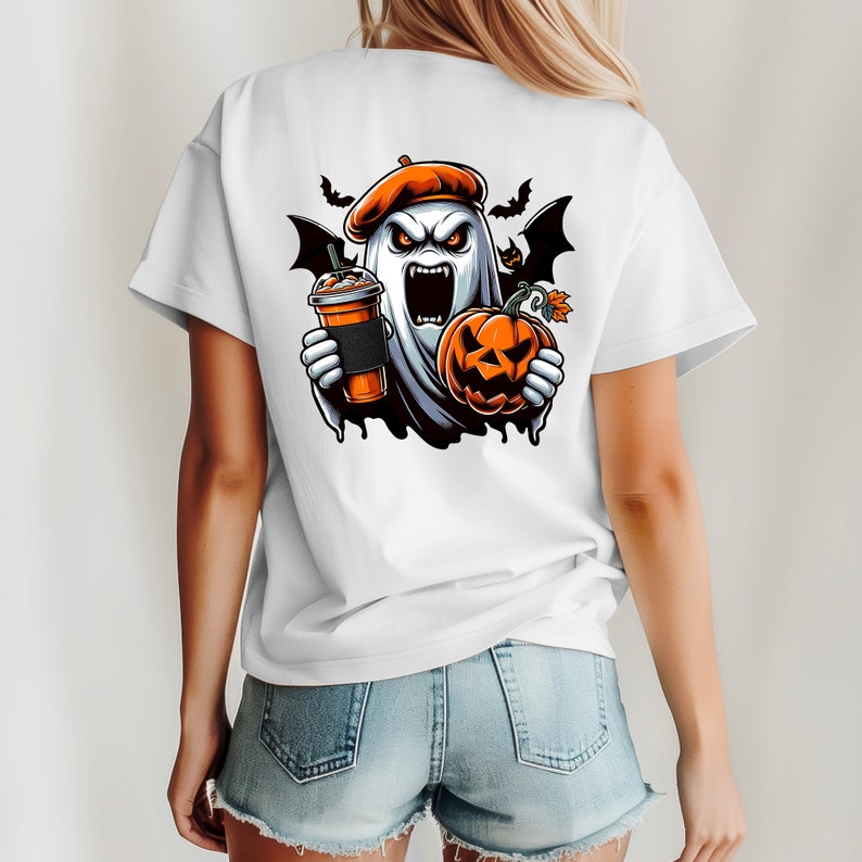 May include: White t-shirt featuring a graphic of a ghost wearing a beret, holding a pumpkin and a cup of coffee. The ghost has a scary expression with fangs and red eyes.