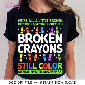 May include: Black t-shirt with the text "We're all a little broken. But the last time I checked, Broken Crayons Still Color" and a row of colorful crayons. The text "Mental Health Awareness" is below the crayons.