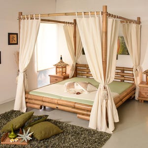 Puede incluir: Una cama con dosel de bambú con cortinas color crema y un colchón verde claro. Dos mesitas de noche de madera con lámparas flanquean la cama. Cojines decorativos y una bandeja con decoración se encuentran sobre una alfombra verde oscuro. El marco de la cama es de bambú.