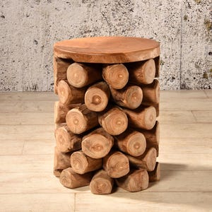 Könnte beinhalten: Ein handgefertigter Beistelltisch aus Holz. Der Tisch hat eine runde Oberseite und eine zylindrische Basis, die aus zahlreichen kleinen, geschnittenen Baumstämmen besteht. Die natürlichen Holztöne erzeugen eine rustikale Ästhetik. Der Tisch ist etwa 46 cm hoch.