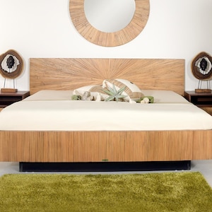 Könnte beinhalten: Ein helles Holzbett mit passendem Kopfteil und zwei Nachttischen. Das Kopfteil hat ein Sonnenstrahl-Design. Das Bett ist mit einer cremefarbenen Bettdecke und Kissen bezogen. Ein grüner Shag-Teppich befindet sich am Fußende des Bettes. Ein runder Spiegel hängt über dem Bett.