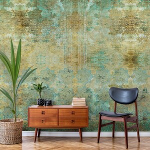 Peut inclure: Une commode de style mi-siècle moderne avec quatre tiroirs en bois chaleureux. La commode est devant un mur avec un papier peint à motifs verts et bruns. Une chaise noire et une plante en pot sont également dans la pièce.