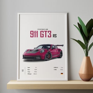 以下が含まれることがあります： 白い額縁に入ったポスターには、白い背景に赤いポルシェ911 GT3 RSスポーツカーが描かれています。ポスターには、エンジンのサイズ、馬力、最高速度など、車の仕様が記載されています。ポスターにはドイツ国旗も描かれています。