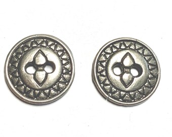 May include: Two antique silver-colored buttons. Each button is round with a central four-petal design and two holes. The outer edge features a repeating triangle pattern. Ideal for sewing and crafts.