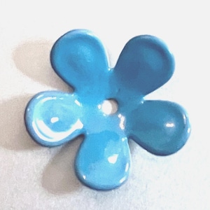 May include: A light blue, five-petal flower-shaped bead with a glossy finish. The bead has a small hole in the center and is set against a white background. The flower's petals are rounded and smooth.