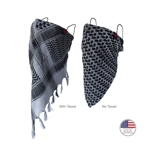 May include: Two black and gray patterned face masks, one with a tassel and one without. The masks are made of fabric and have elastic ear loops. The text "With Tassel" and "No Tassel" is printed below each mask. A small American flag with the text "U.S.A." is printed in the bottom right corner.