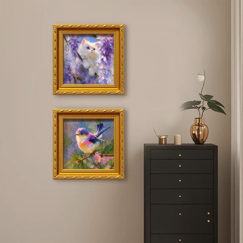 Puede incluir: Dos pinturas enmarcadas con marcos dorados ornamentados. La pintura superior representa un gato blanco en flores moradas. La pintura inferior muestra un p&aacute;jaro colorido en una rama. Las pinturas est&aacute;n en una pared neutra.