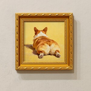 Pu&ograve; includere: Dipinto incorniciato di un cane corgi da dietro, con il suo soffice fondoschiena rivolto allo spettatore. Il cane ha un mantello marrone-rossiccio e bianco e giace su uno sfondo giallo. Il dipinto &egrave; in una cornice dorata ornata.