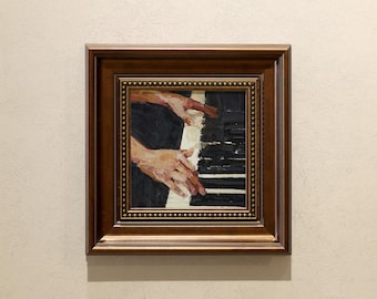 May include: Oil painting of hands playing a piano, framed in a dark brown wooden frame. The artwork depicts the hands of a person with visible brushstrokes, poised over the black and white keys. The background is a dark color.