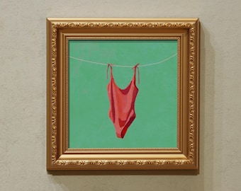 May include: A framed artwork depicting a red swimsuit hanging on a washing line against a green backdrop. The artwork is in a gold ornate frame, giving a vintage feel. The swimsuit is the central element of the image.