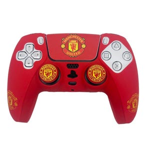 May include: Red games controller featuring the Manchester United logo. The controller has silver buttons and a black centre panel. The Manchester United logo is displayed on the top and on the two circular buttons.