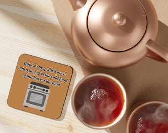 May include: A square coaster with a tan background featuring a graphic of a white oven and the text: Why do they call it oven when you of in the cold food of out hot eat the food. Beside it sits a copper teapot and two cups of steaming tea.
