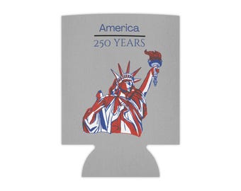 May include: A grey foam can cooler featuring a graphic of the Statue of Liberty in red, white, and blue. Above the statue, the text reads America 250 YEARS in blue and black lettering. The cooler has a curved bottom cutout for a standard beverage.