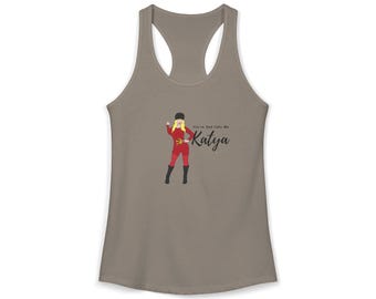 May include: A taupe racerback tank top featuring a graphic illustration of a blonde figure in a red outfit, black hat, and black boots, holding a gold hammer and sickle. The text reads "You're Dad Calls Me Katya" in black script lettering.