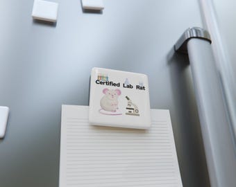 May include: A square white refrigerator magnet featuring a cartoon illustration of a light grey mouse, a microscope, and colourful test tubes. The text "Certified Lab Rat" is printed in black letters across the top of the magnet surface.