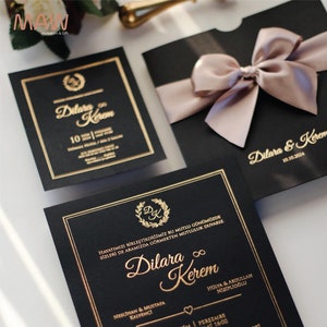 Luxe zwart-gouden huwelijksuitnodigingssuite met satijnen lint en aangepaste foliegestempelde tekst, perfect voor elegante bruiloften en formele evenementen