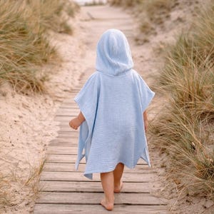 Könnte beinhalten: Ein Set aus drei Keramikbechern mit gesprenkelter, matter Oberfläche. Die Becher sind in Creme-, Hellgrau- und Dunkelgrautönen gehalten. Jeder Becher hat ein schlichtes, minimalistisches Design und einen abgerundeten Henkel.