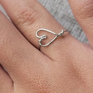 May include: A silver wire ring with a heart design.
