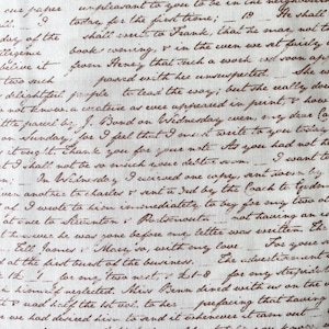 May include: A light-colored fabric featuring a repeating pattern of dark brown cursive handwriting. The text mimics vintage correspondence with visible ink strokes, loops, and varying line density, creating a dense, manuscript-style aesthetic across the surface.