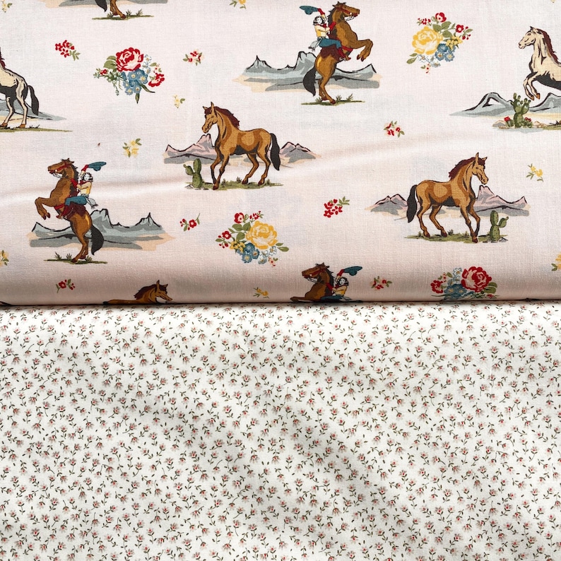 May include: Two fabric patterns. The top fabric has a cream background with a repeating pattern of cowboys on horses, mountains, cacti, and floral bouquets in red, yellow, and blue. The bottom fabric has a white background with a small, repeating floral pattern in red and brown.