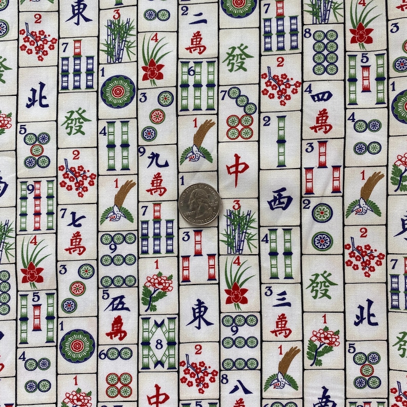 May include: A fabric featuring a repeating pattern of Mahjong tiles. The tiles are white with black, red, green, and blue symbols and characters. The design includes bamboo, flowers, and circles. A quarter is included for scale.