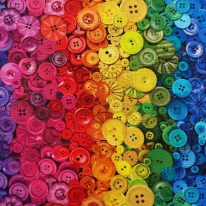 May include: A vibrant array of colorful buttons arranged in a gradient from purple to blue. The buttons vary in size and style, with two-hole and four-hole designs. The color spectrum includes shades of red, orange, yellow, green, and blue.
