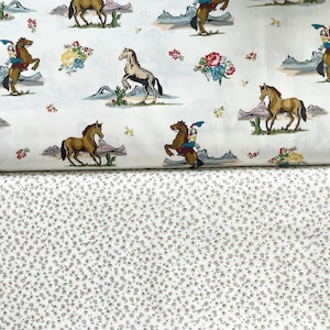 May include: White fabric featuring a repeating design of horses, cowboys, cacti, and floral arrangements in brown, blue, red, and yellow. Beneath is a fabric with a small, repeating floral pattern in white and brown.
