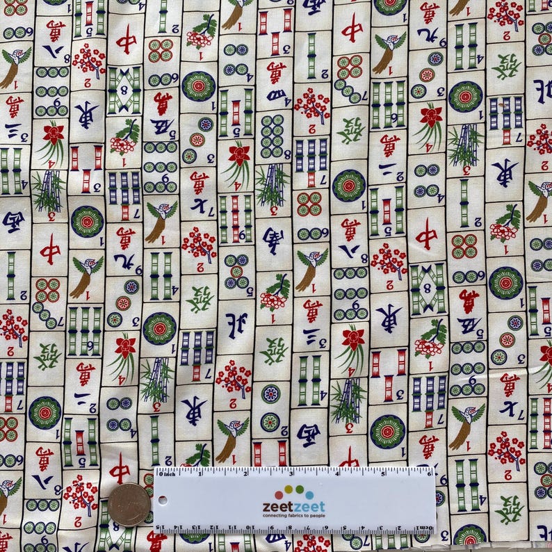 May include: Cream-colored fabric with a repeating pattern of Mahjong tiles. The tiles feature Chinese characters, numbers, and colorful illustrations of flowers, bamboo, and birds. A ruler is at the bottom.
