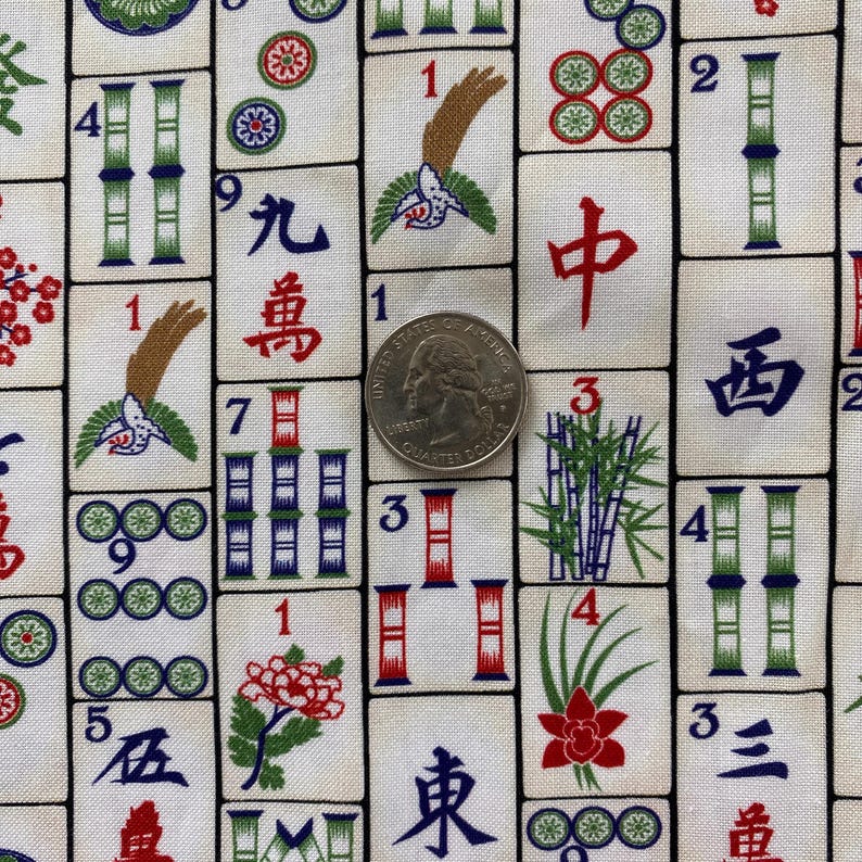 May include: Close-up of a fabric featuring a repeating pattern of Mahjong tiles. The tiles are white with various symbols, numbers, and illustrations in red, green, and blue. A U.S. quarter is included for scale.