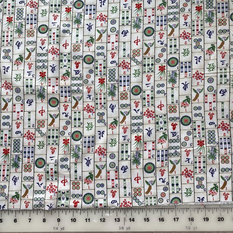 May include: White fabric with a repeating pattern of colorful Mahjong tiles. The tiles feature Chinese characters, numbers, and decorative elements in red, green, blue, and gold. The fabric is suitable for sewing and crafting projects.