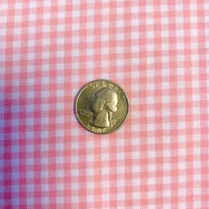 May include: A silver US quarter with the year 1977 and the words "In God We Trust" and "Liberty" on it.