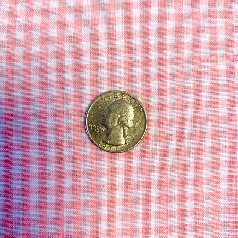 May include: A silver US quarter with the year 1977 and the words "In God We Trust" and "Liberty" on it.